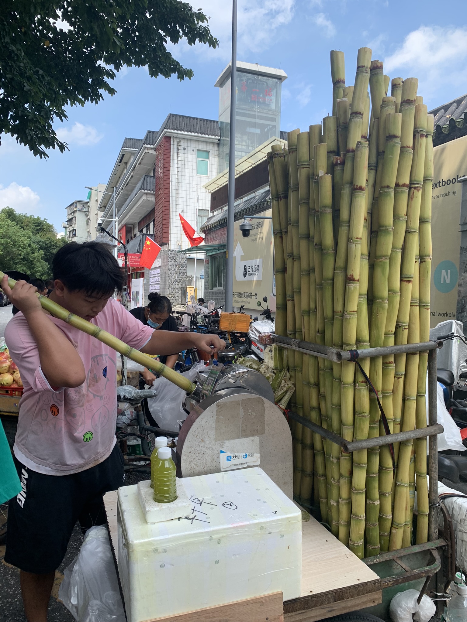 man using machine to juice sugar cane