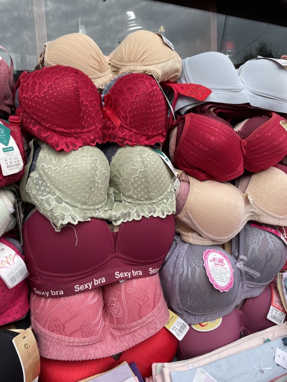 close up of bras on sale, one of which has "sexy bra" written on the band