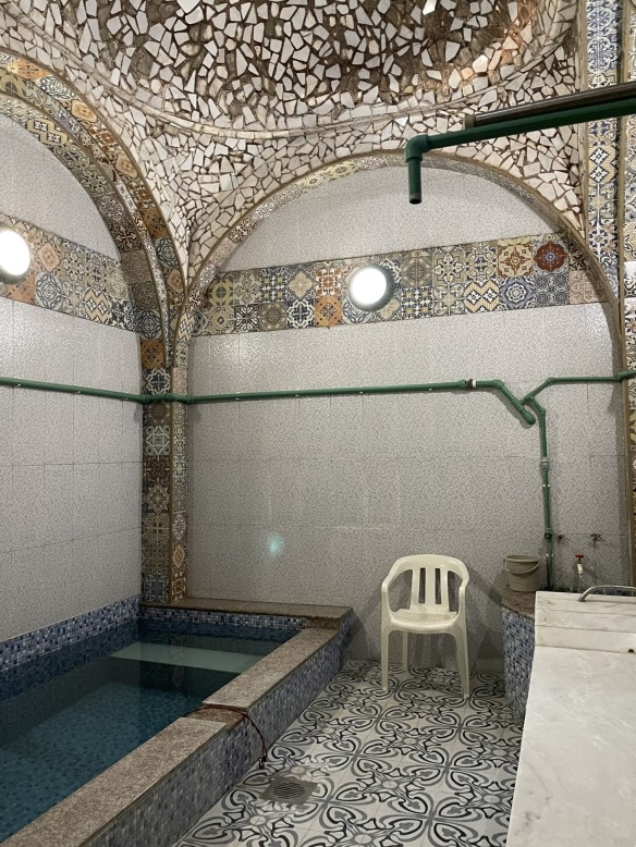 tiled bathing room with pool and marble slab.